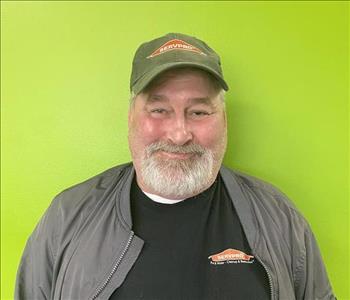 SERVPRO employee standing in front of orange wall