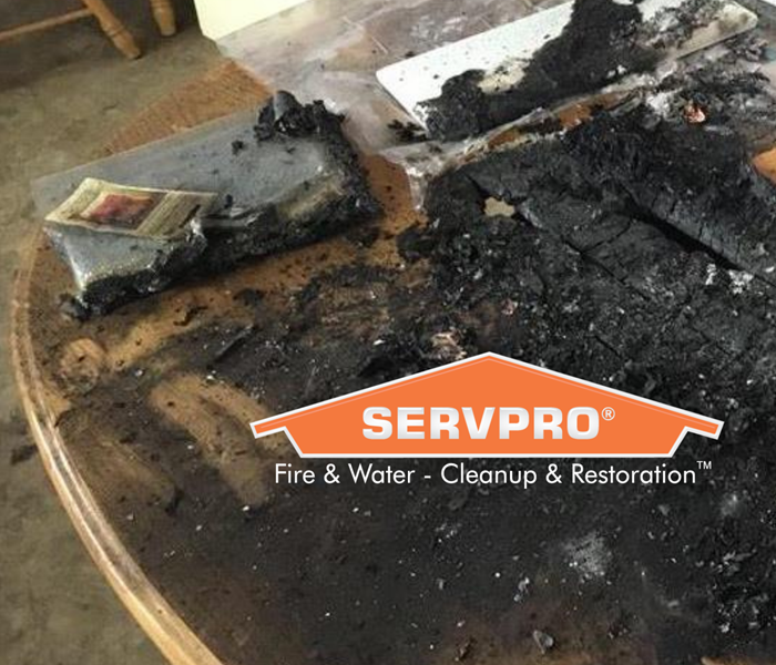 SERVPRO logo on fire damaged table