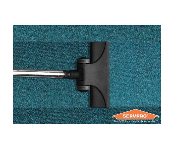SERVPRO logo with vacuum on blue carpet