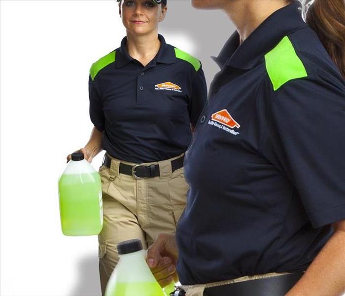 SERVPRO Certified Cleaned by two ladies in blue shirts holding SERVPRO products. 